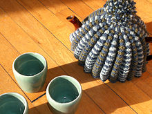 teapot on a table with a woollen teacosy