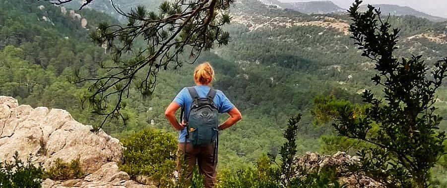 rear view of a female hiker looking out over mountains